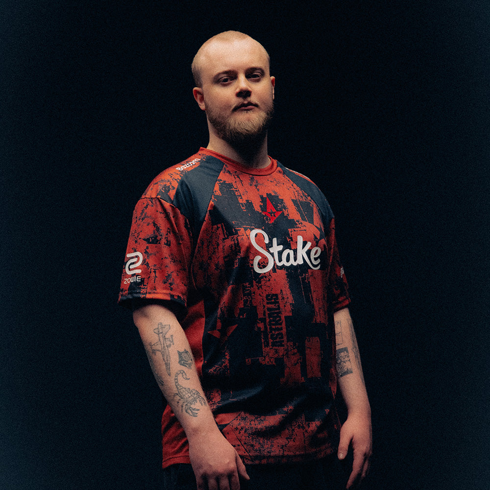PHZY wearing a red and black patterned Astralis jersey with Stake branding against a dark background